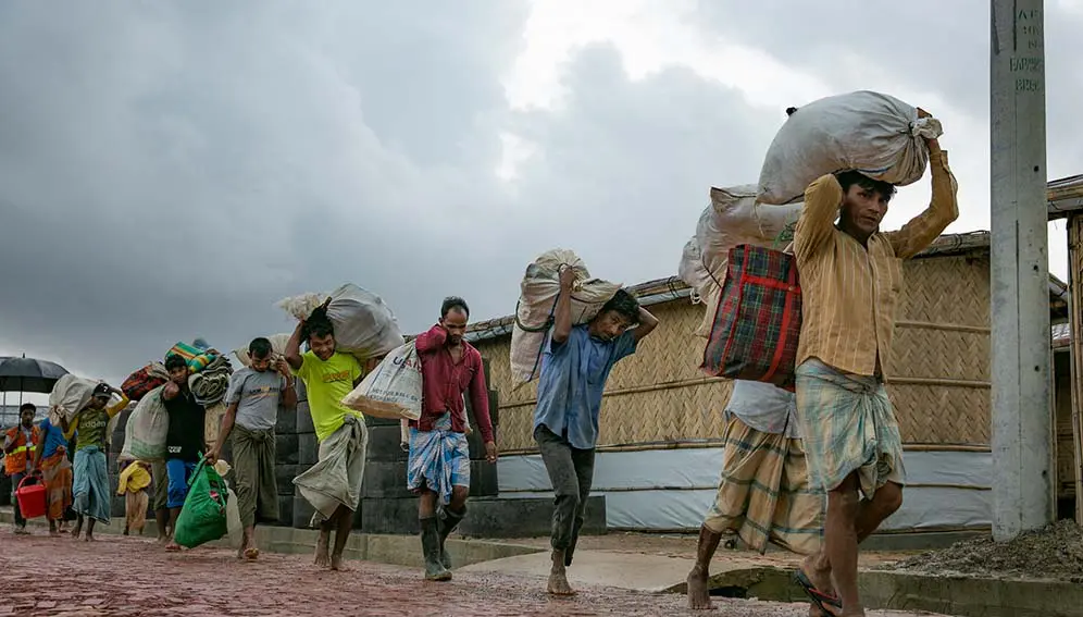 Rohingya refugees relocating because of flooding and landslides in the Balukhali refugee camp in Cox's Bazar, Bangladesh in 2019. A new study indicates that in some situations, vulnerable populations are simply unable to leave, even if they want to. Copyright: UN Women/Allison Joyce, (CC BY-NC-ND 2.0)