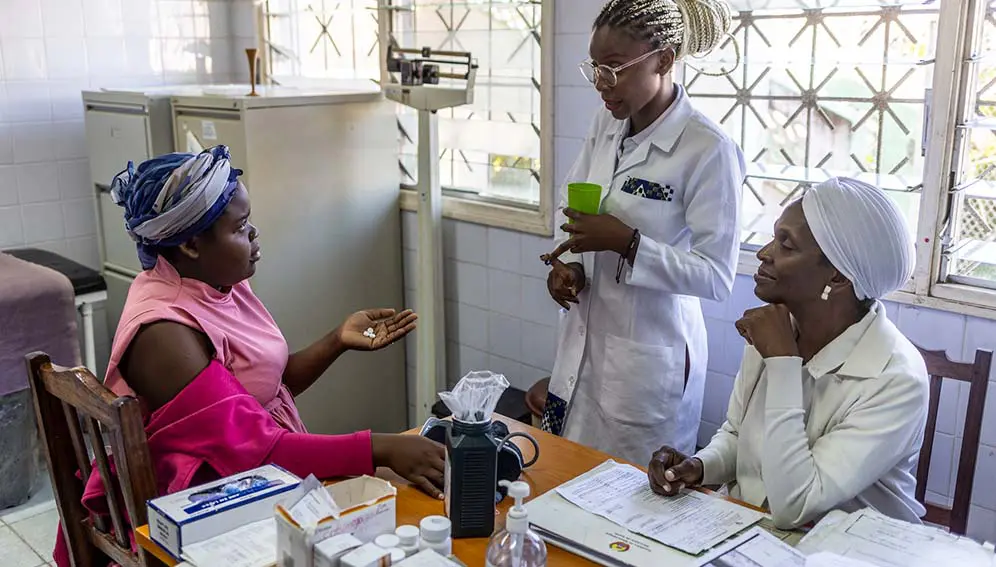 Mariana Fabio, a patient, discussing a prescription with clinical staff in Zambezia province in Mozambique. A researcher has said doctors might need to prescribe different medication or add probiotics when treating African patients. Copyright: USAID Mozambique, (Public domain).
